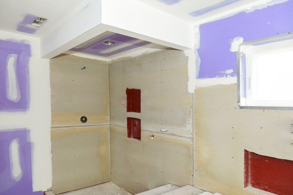 Bathroom remodel progresses as drywall is smoothed